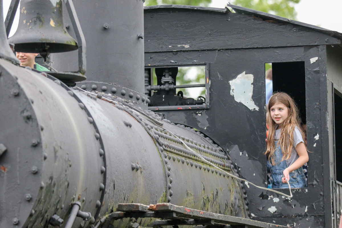 Quinn Oparka rings the bell in a historic steam locomotive at Shelby Township's SummerFest, showcasing one of the festival's unique family-friendly attractions.